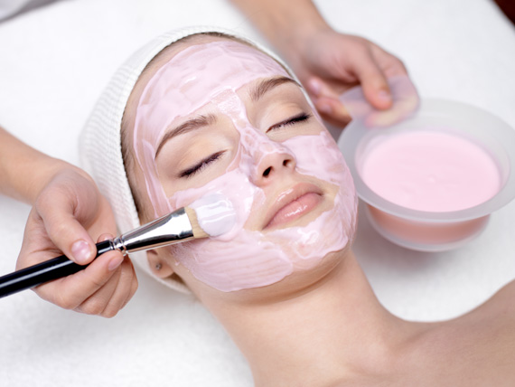 Bild von Frau mit rosa Gesichtsmaske und Pinsel